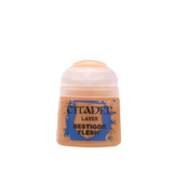 A squat paint pot with a translucent peach-colored cap and a tan label splashed with blue. The label reads “CITADEL,” “LAYER,” and “BESTIGOR FLESH.”