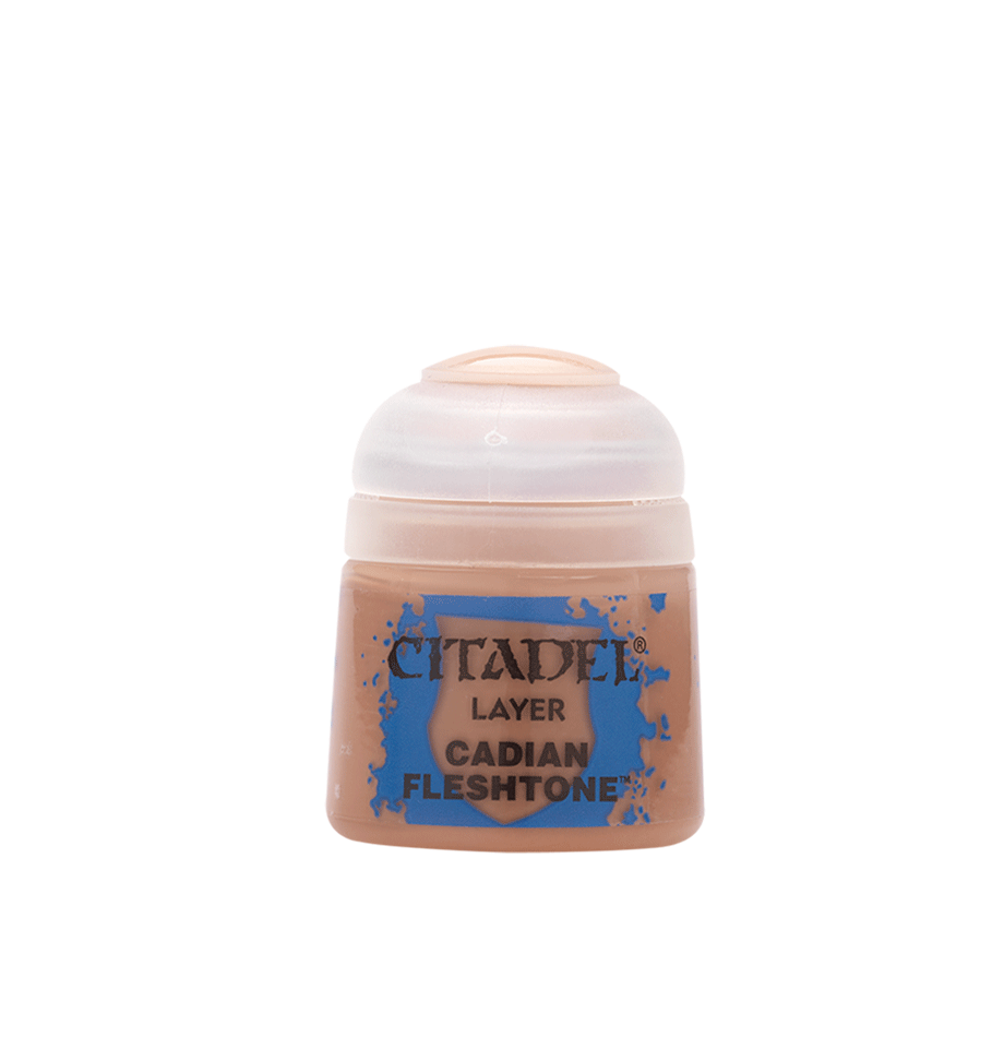 A small peach-toned Citadel paint pot stands upright against a plain green background, with a pale translucent flip-top lid and blue splatter label reading “CITADEL,” “LAYER,” and “CADIAN FLESHTONE.”