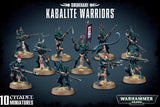 Box art showing ten armed Kabalite Warrior miniatures in dark armor with teal highlights, posed on round sandy bases; one carries a tall purple banner. The text reads “DRUKHARI,” “KABALITE WARRIORS,” and “10 CITADEL MINIATURES.”