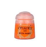 A small bright orange paint pot stands upright against a plain dark green background, with a pale pink translucent cap and a gold-and-orange label reading “CITADEL,” “DRY,” and “RYZA RUST.”