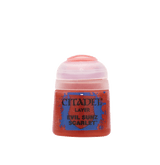 Small red Citadel paint pot shown upright against a plain dark green background, with a pale pinkish-white flip-top lid and a blue-and-red label reading “CITADEL,” “LAYER,” and “EVIL SUNZ SCARLET.”