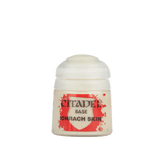 A small pale cream Citadel paint pot with a rounded white cap and red-and-white label, shown upright against a plain green background. The label reads “CITADEL,” “BASE,” and “IONRACH SKIN.”