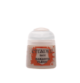 A small pale beige Citadel paint pot with a white flip-top lid, shown upright from the front. Its orange splatter label reads “CITADEL,” “BASE,” and “RAKARTH FLESH.”