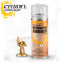 A tall spray paint can with a clear cap and orange-gold label stands beside a small gold-colored armored miniature. The label reads “CITADEL RETRIBUTOR ARMOUR” and “MODEL PAINT”; warning symbols appear near the bottom.