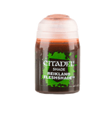 A small upright Citadel shade paint pot with a white cap and dark reddish-brown liquid. Its green-and-black label reads “CITADEL,” “SHADE,” and “REIKLAND FLESHSHADE.”
