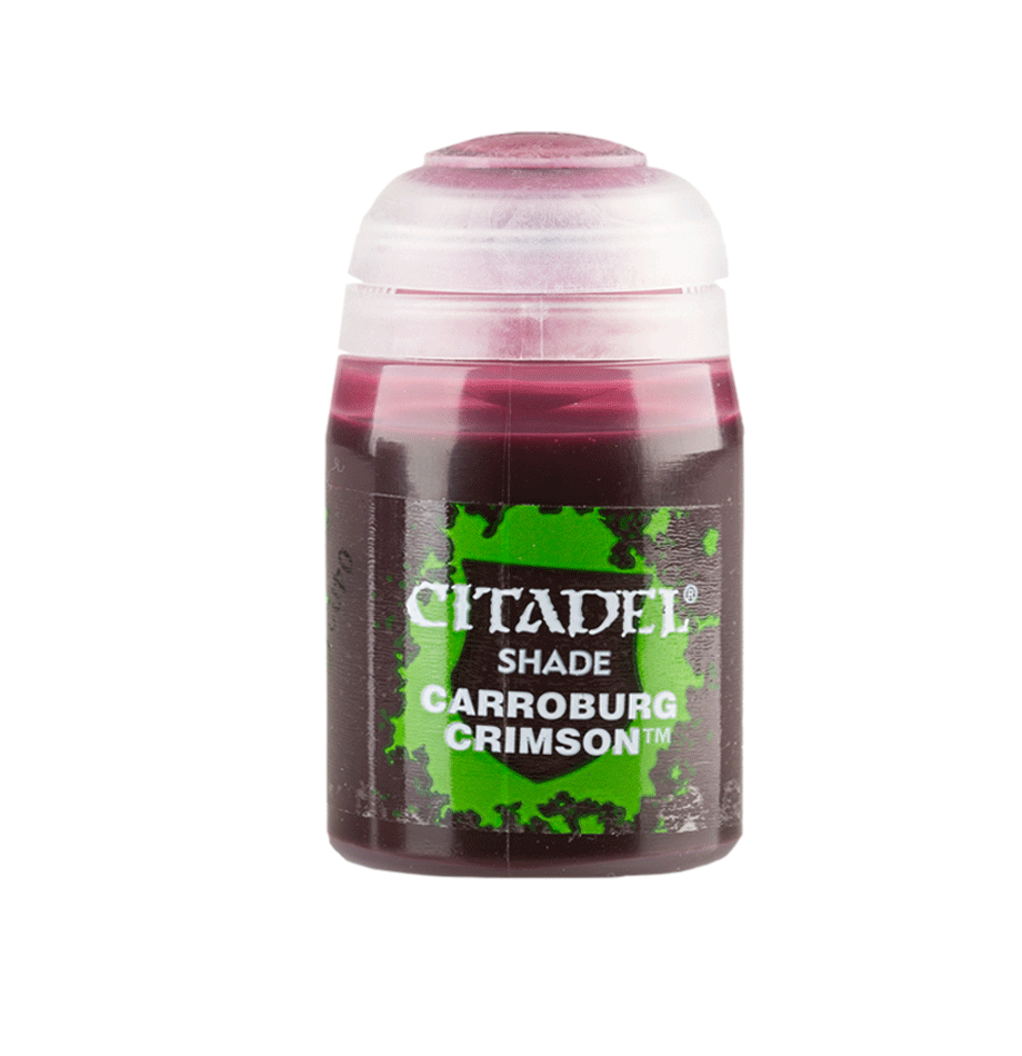 A small paint bottle stands upright against a plain green background, with a white cap and dark crimson liquid visible through the container. Its black-and-green label reads “CITADEL” and “SHADE CARROBURG CRIMSON.”