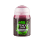 A small paint bottle stands upright against a plain green background, with a white cap and dark crimson liquid visible through the container. Its black-and-green label reads “CITADEL” and “SHADE CARROBURG CRIMSON.”
