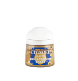 A small paint pot with a broad white cap and a gold-and-blue label, shown upright against a plain green background. The label reads “CITADEL,” “LAYER,” and “SKULLCRUSHER BRASS.”