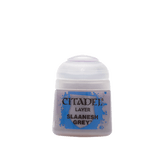 A small squat pot of pale grey miniature paint with a white flip-top lid and a blue splatter-style label. The label reads “CITADEL,” “LAYER,” and “SLAANESH GREY.”