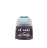 Small Citadel paint pot shown upright, with a pale blue-gray flip-top cap and a dark blue label patterned with red-orange splashes. The label reads “CITADEL,” “BASE,” and “STEGADON SCALE GREEN.”
