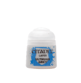 A small white Citadel paint pot shown upright, with a white domed cap and a blue splatter label reading “CITADEL,” “LAYER,” and “ULTHUAN GREY.”