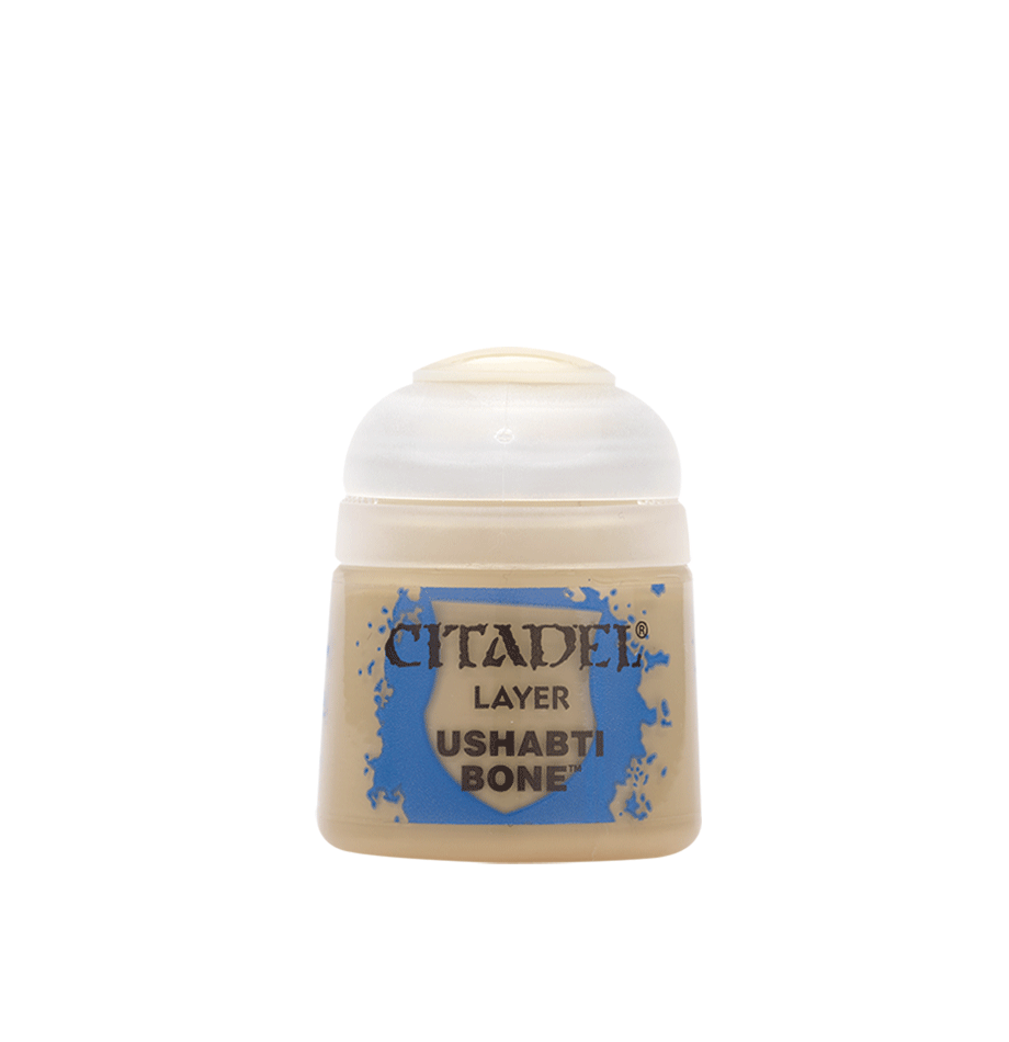 A small beige paint pot with a rounded white cap and a blue splatter design on its front label. The label reads “CITADEL,” “LAYER,” and “USHABTI BONE.”