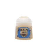 A small beige paint pot with a rounded white cap and a blue splatter design on its front label. The label reads “CITADEL,” “LAYER,” and “USHABTI BONE.”