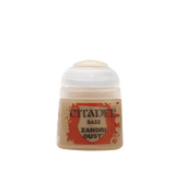 A small, squat bottle of beige miniature paint shown upright against a plain green background, with a white ridged cap and a red-and-tan label reading “CITADEL,” “BASE,” and “ZANDRI DUST.”