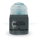A squat bottle of dark gray airbrush paint stands front-facing, with a pale blue-gray cap and a dark label reading “CITADEL COLOUR,” “AIR,” and “MECHANICUS STANDARD GREY.”