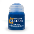 A squat, rounded bottle of deep blue paint with a wide pale blue cap, shown upright against a white background. The label reads “CITADEL COLOUR,” “CONTRAST,” and “ULTRAMARINES BLUE.”
