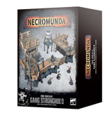 Box for Necromunda: Zone Mortalis Gang Stronghold, shown from the front and right side. The front depicts dark gray industrial terrain with orange-brown details and small figures, beneath “NECROMUNDA” and “GANG STRONGHOLD”; the side repeats the title vertically.