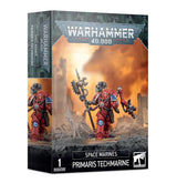 Box for a Space Marines Primaris Techmarine miniature, shown from the front and left side. Artwork depicts a red-armored figure carrying a staff and mechanical arm against an orange battlefield; the box reads “WARHAMMER 40,000,” “SPACE MARINES” and “PRIMARIS TECHMARINE.”