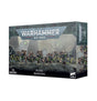 A dark gray Warhammer 40,000 Necrons: Warriors miniature box, shown from the front and right side. Its artwork depicts a line of skeletal armored figures with green accents; the front reads “WARHAMMER 40,000,” “NECRONS WARRIORS,” and “13 MINIATURES.”