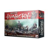 Warcry: Khainite Shadowstalkers game box shown at an angle, with a red and black design and fantasy warriors among rocky terrain on the front; the side repeats the artwork. Prominent text reads “WARCRY” and “KHAINITE SHADOWSTALKERS.”