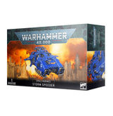 Box for a Space Marines Storm Speeder miniature, shown from the front and right side. The front depicts a blue armored flying vehicle against an orange, fiery city scene, with the text “WARHAMMER 40,000,” “SPACE MARINES,” and “STORM SPEEDER.”