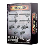 Box for Necromunda Goliath Weapons & Upgrades, shown from the front and right side. The weathered gray front displays rows of dark metallic weapon components on a grid, with orange-and-black “NECROMUNDA” lettering and white “GOLIATH WEAPONS & UPGRADES” text; the side repeats the title.