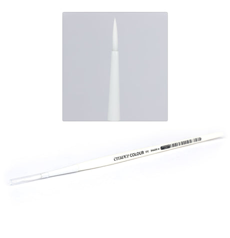 A slim white Citadel brush lies diagonally with a clear protective cap over its tip; an inset shows the pointed white bristles close up. Gray handle lettering reads “CITADEL® COLOUR” and “STC.”