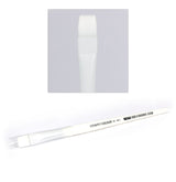 A white Citadel dry brush lies diagonally, with a white handle, broad flat white bristles and black lettering reading “CITADEL COLOUR” and “STC DRY.” An inset above shows a close-up of the bristle tip.