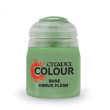 A squat pale green paint pot with a translucent light gray-green cap, shown upright against a white background. Its front label reads “CITADEL COLOUR,” “BASE,” and “ORRUK FLESH.”