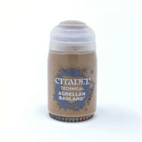 A small tan Citadel paint pot stands upright against a white background, with a pale lavender-white ridged cap and a blue-and-tan label reading “CITADEL,” “TECHNICAL” and “AGRELLAN BADLAND.”
