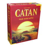 Red and yellow Catan board game box shown at an angle, with the front and left spine visible. The front depicts a huge setting sun over a landscape with settlers and reads “CATAN” and “TRADE BUILD SETTLE”; “CATAN” also runs vertically on the spine.