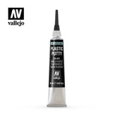 A small upright tube of Vallejo plastic putty on a white background, with a long black pointed nozzle, ribbed silver cap and base, and a black label reading “PLASTIC PUTTY” and “vallejo.”