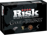 Black Risk: Game of Thrones board game box shown at an angle, with a dark map across the front and side. The front reads “RISK” and “GAME OF THRONES,” above four illustrated house sigils.