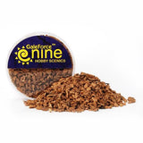 A clear round tub of brown, angular rocky basing grit sits behind a pile of the same material spilled onto a white surface. Its purple-and-yellow label reads “GaleForce nine” and “HOBBY SCENICS.”