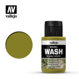 A Vallejo Model Wash bottle with a black cap and olive-green label stands beside a round olive-green color swatch. The bottle label reads “MODEL WASH” and “Dark Green,” with the Vallejo logo above.