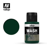 A dark olive-green paint wash bottle with a black ribbed cap stands beside a matching circular color swatch on a white background. The label reads “vallejo,” “MODEL WASH,” and “Olive Green.”