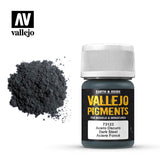 A mound of charcoal-gray pigment sits beside a small dark bottle with a ribbed white cap. The label reads “VALLEJO PIGMENTS” and “Dark Steel,” with the Vallejo logo above.