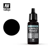 Vallejo black Surface Primer in a small black bottle with a ribbed dropper cap, shown beside a solid black circular swatch. The label reads “SURFACE PRIMER,” “70.602,” “Negro,” and “Black,” with the Vallejo logo above.