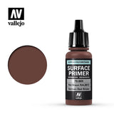 Vallejo Surface Primer bottle with a black dropper cap and dark red-brown contents, shown beside a circular swatch of the same color. The label reads “SURFACE PRIMER,” “70.605,” and “German Red Brown.”