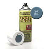 A tall spray primer can with a yellow-green label and silver-and-black nozzle stands beside its white cap, which lies on its side. The label reads “THE ARMY PAINTER”; a blue-gray color swatch is marked “Wolf Grey CP3021.”
