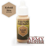 A small paint bottle with a white dropper cap and tan paint visible at the neck. Its dark green and yellow label reads “THE ARMY PAINTER WARPAINTS” and “Kobold Skin”; a tan color swatch marked “Kobold Skin WP1434” appears at upper left, with an Army Painter logo at lower right.