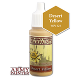 A small upright bottle of Desert Yellow hobby paint with a white pointed cap and yellow-tan liquid, shown against black. Its label reads “THE ARMY PAINTER” and “WARPAINTS”; a mustard-gold hexagon beside it reads “Desert Yellow” and “WP1121.”