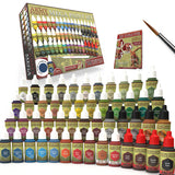 The Army Painter Mega Paint Set is displayed with rows of small paint bottles in many colors, plus a brush and illustrated guide booklet. The box behind them reads “THE ARMY PAINTER MEGA PAINT SET.”